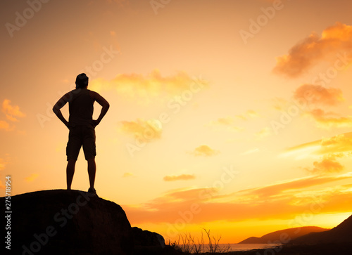 Thoughtful man standing on a mountain looking at the view. Inspirational, and new day concept