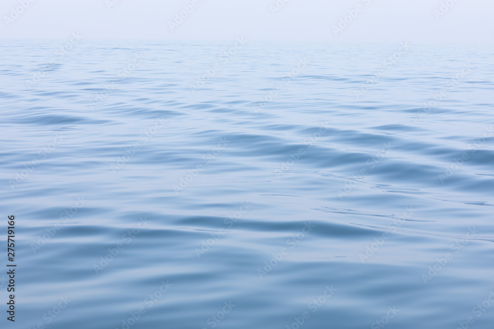 Tranquil and serene ocean surface. Calm and relaxed mirror-like blue sea background. Tranquil and serene ocean surface. Calm and relaxed mirror-like blue sea background.