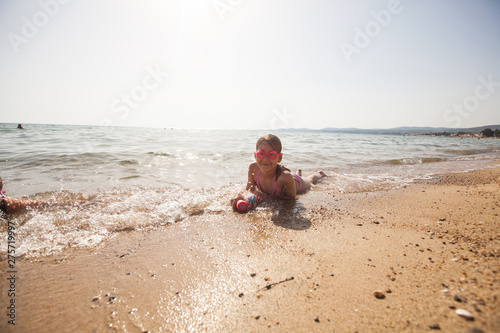 Happy little girl enjoy on sandy beach during summer vacation