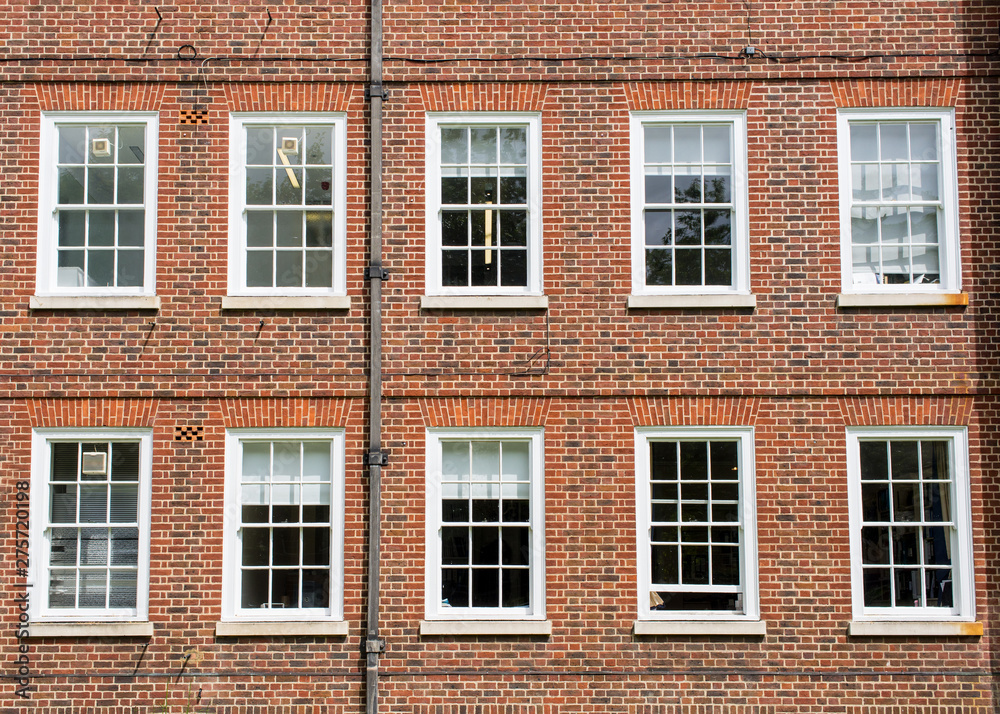 Eight windows with white sash and frame on a red brick wall Georgian British style