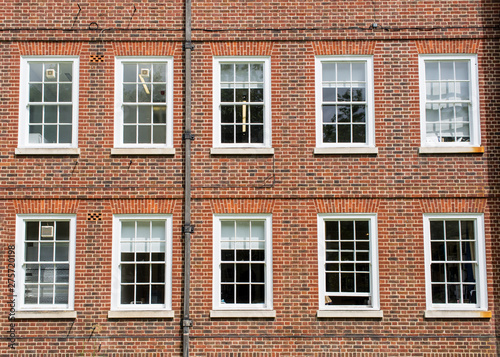 Eight windows with white sash and frame on a red brick wall Georgian British style
