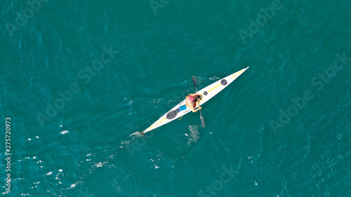 Aerial drone photo of fit man practising sport canoe in calm water sea