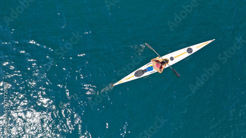 Aerial drone photo of fit man practising sport canoe in calm water sea