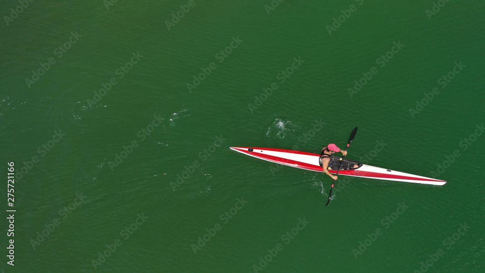 Aerial top view photo of fit athlete practising sport canoe in tropical exotic Caribbean destination with emerald calm sea Aerial top view photo of fit athlete practising sport canoe in tropical exotic Caribbean destination with emerald calm sea