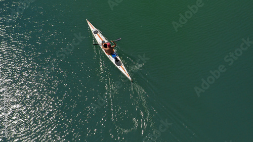 Aerial top view photo of fit athlete practising sport canoe in tropical exotic Caribbean destination with emerald calm sea