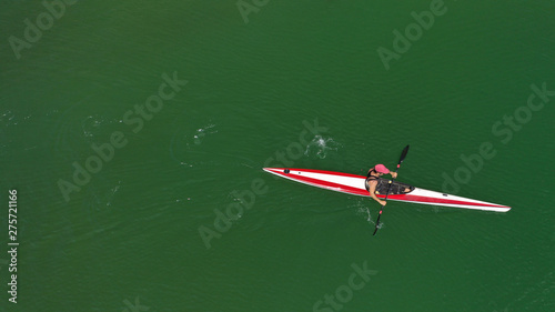 Aerial top view photo of fit athlete practising sport canoe in tropical exotic Caribbean destination with emerald calm sea