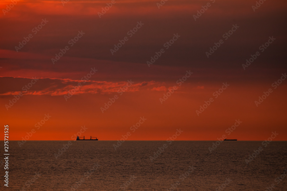 Cargo ships on a ship route on the open sea in the evening light.