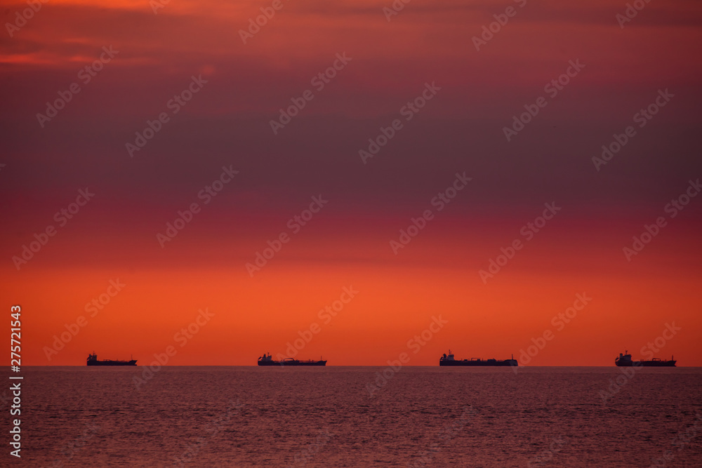 Energy import. Cargo ships on a ship route on the open sea in the evening light.
