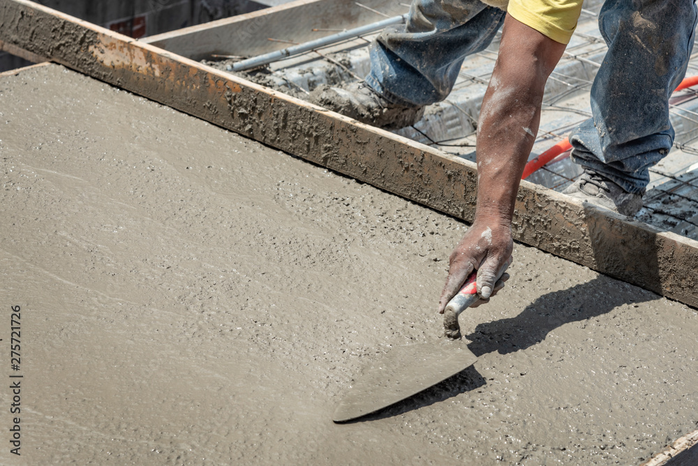 Bricklayer leveling a cement roof. Stretching out to smooth the casted concrete mix Bricklayer leveling a cement roof. Stretching out to smooth the casted concrete mix