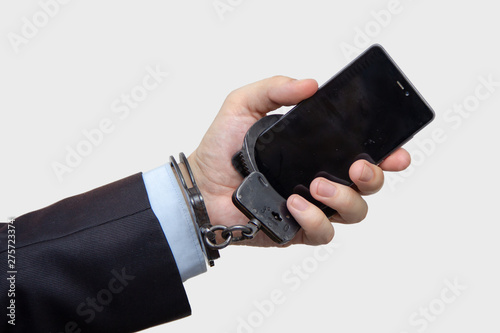 Hand of a man in handcuffs with telephone, Internet addiction photo