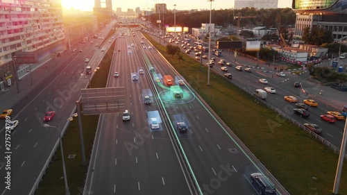 Beautiful aerial view to autonomous cars self-driving on the highway in Moscow. Picturesque aerial panorama of the road traffic in a big city on the sunset. photo