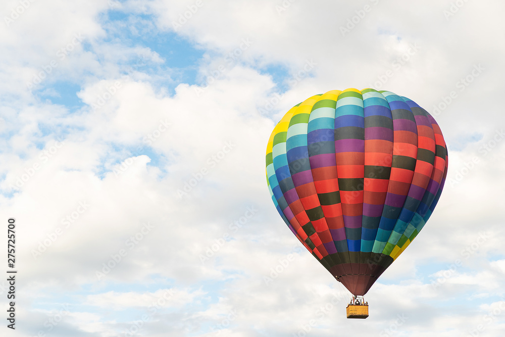Fototapeta premium Two hot air balloons floating under vibrant blue sky with puffy white clouds