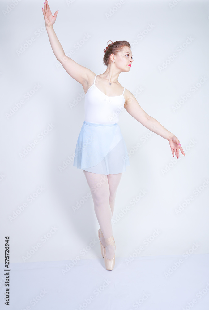 cute caucasian girl in ballet clothes learning to be a ballerina on a white background in the Studio. plus size young woman dreams of being a dancer. cute caucasian girl in ballet clothes learning to be a ballerina on a white background in the Studio. plus size young woman dreams of being a dancer.
