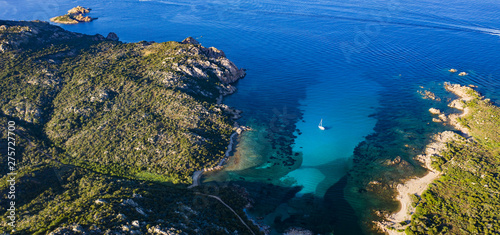 View from above, stunning aerial view of a sailing boat floating on a beautiful turquoise clear sea. Maddalena Archipelago National Park, Sardinia, Italy.