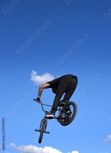 Silhouette eines waghalsigen BMX-Bikers vor strahlend blauem Himmel