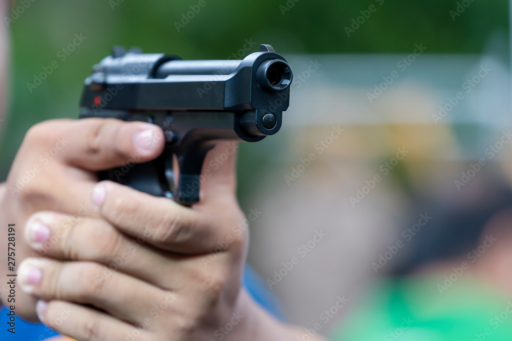 Man holding gun aiming pistol in hand ready to shoot. The Criminal robber or gangster, thief, concept Man holding gun aiming pistol in hand ready to shoot. The Criminal robber or gangster, thief, concept