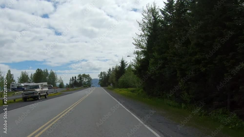 POV, Drive on Ballaine Blvd in Seward AK, visible are the campground at Waterfront Park, multiple homes, and trees along the road; Resurrection Bay, Kenai mountains are visible in the background POV, Drive on Ballaine Blvd in Seward AK, visible are the campground at Waterfront Park, multiple homes, and trees along the road; Resurrection Bay, Kenai mountains are visible in the background