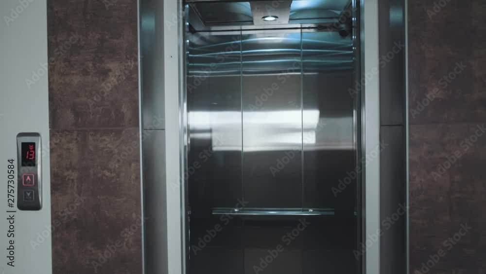 The elevator doors open. Opening the door is an elevator. Metal doors smoothly open and close. Silver and beige new elevator in 4k video. The elevator doors open. Opening the door is an elevator. Metal doors smoothly open and close. Silver and beige new elevator in 4k video.