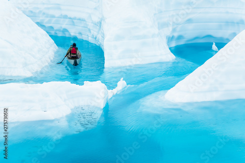 Exploring a melting glacier by canoe, a young man paddles into a canyon flooded by warming temperatures.