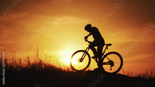 Wallpaper Mural Healthy active lifestyle sports of fitness man exercising at sunset. Silhouette of an athlete cyclist man is drinking water after intensive cycling biking training. on the natural rural background. Torontodigital.ca