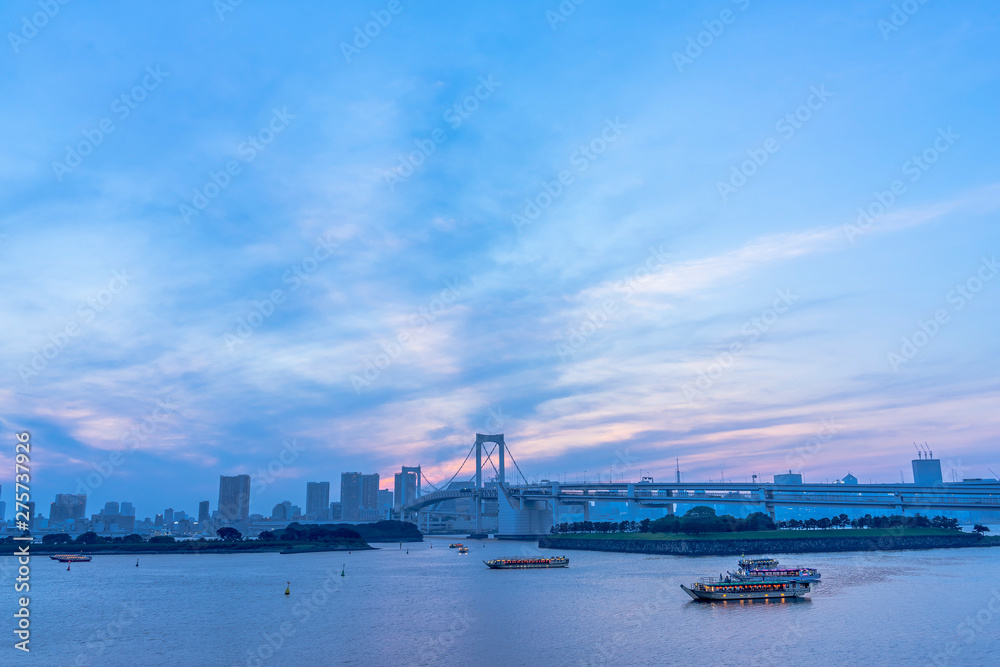 Naklejka premium お台場 ライトアップしたレインボーブリッジと屋形船が浮かぶ風景