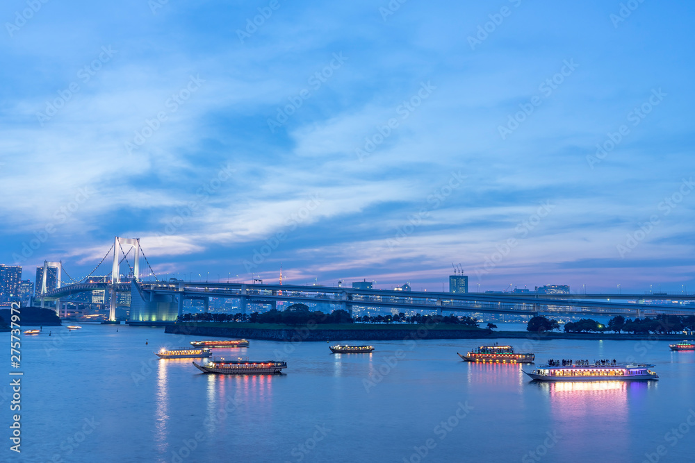 東京港区お台場　ライトアップしたレインボーブリッジと屋形船が浮かぶ風景