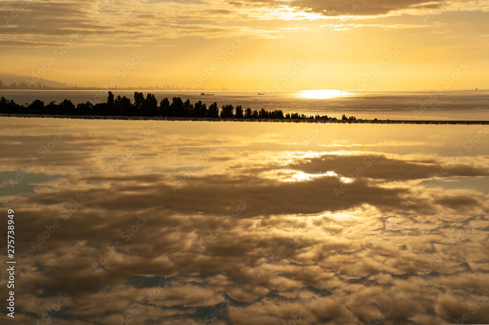 美しい朝焼けと水たまりに映り込む雲