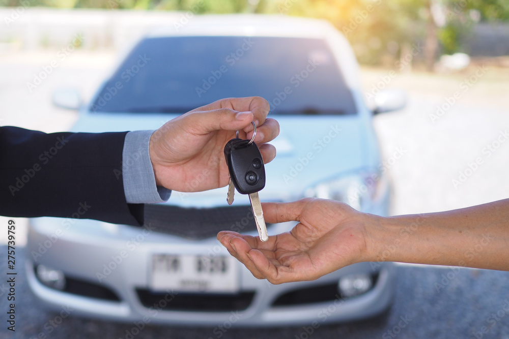 Car salesmen send keys to new car owners. Used car sales agency, car rental