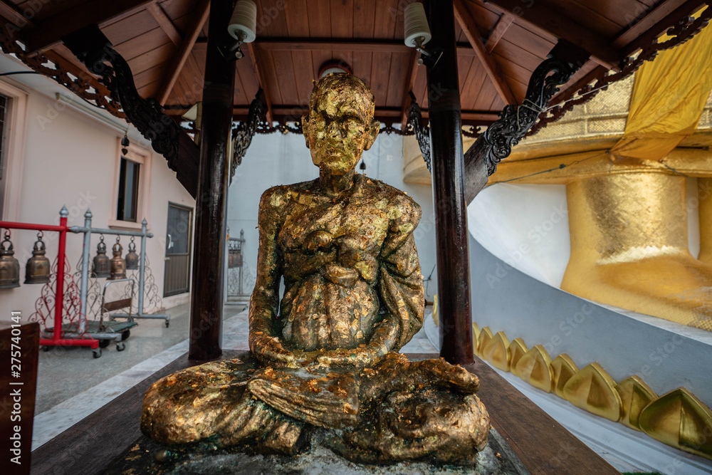 Fototapeta premium a small golden Buddha at wat Intharawihan. This 32 metre high and 10 feet wide Buddha is the biggest of its kind in the world. Wat Intharawihan is on wisut Kasat road Bangkok Thailand