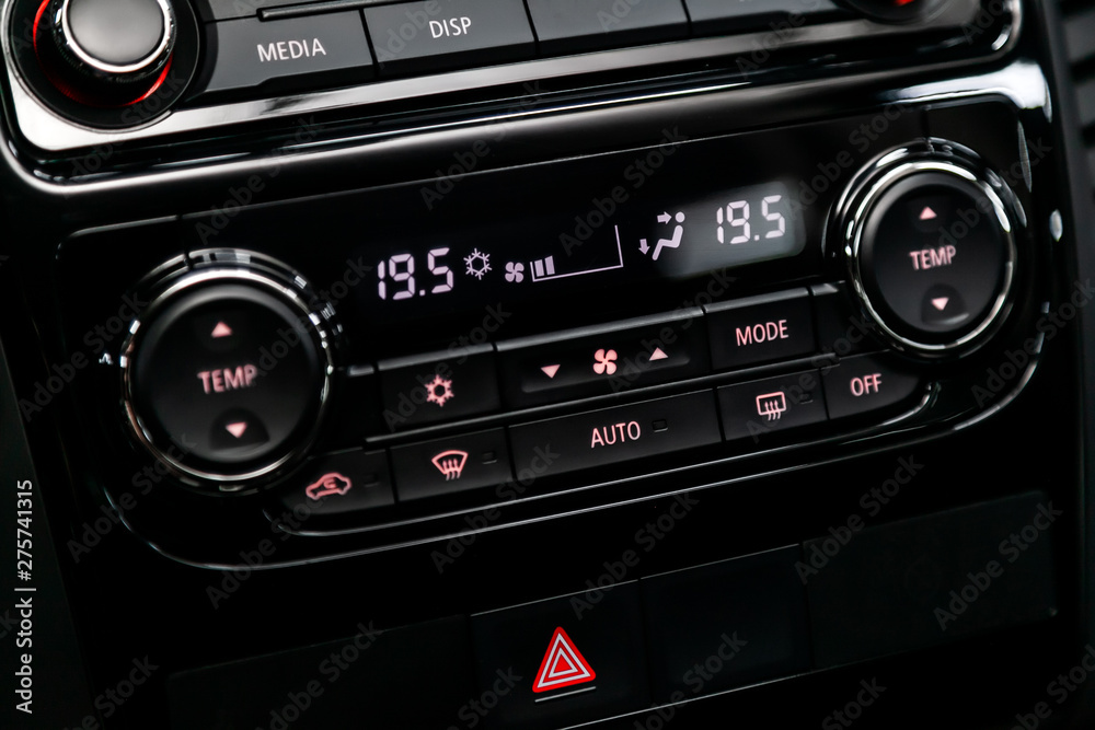 Black detail with the air conditioning button, the dashboard with information about temperature inside a car. modern car interior: parts, buttons, knobs.. Black detail with the air conditioning button, the dashboard with information about temperature inside a car. modern car interior: parts, buttons, knobs..
