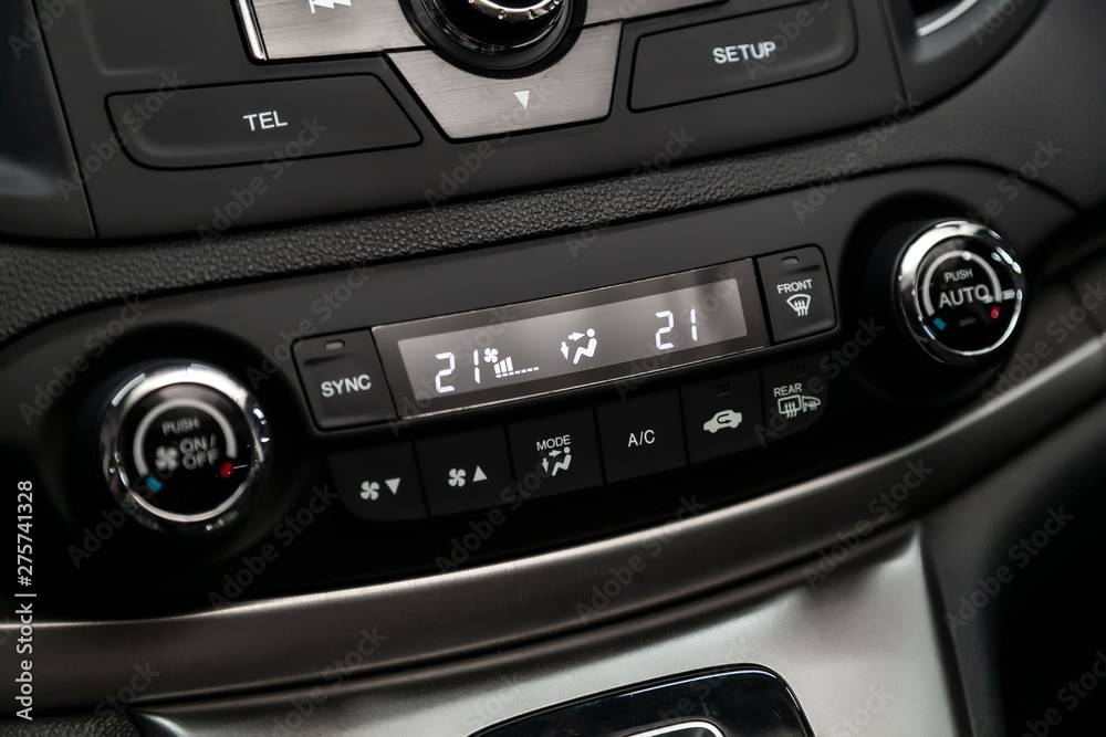 Black detail with the air conditioning button, the dashboard with information about temperature inside a car. modern car interior: parts, buttons, knobs..