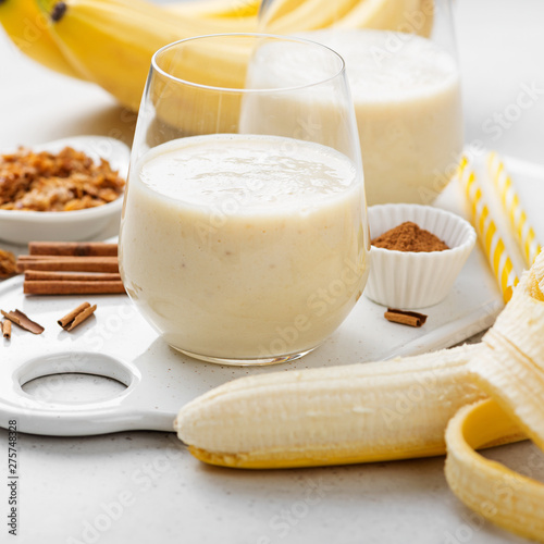 Banana smoothie in glass with granola and cinnamon for healthy breakfast.