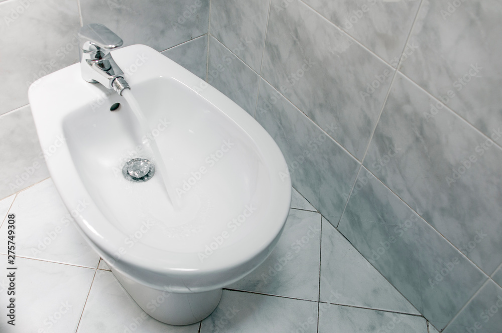 Fototapeta premium Bidet with running water top down, with copy space.