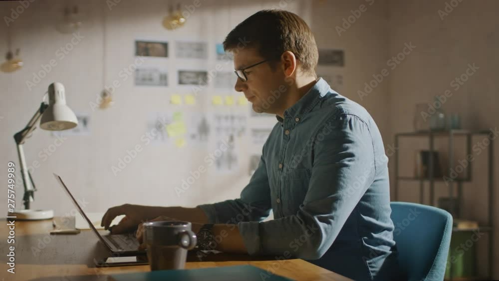Professional Creative Man Sitting at His Desk in Home Office Studio Working on a Laptop. Man working with Data and Analyzing Statistics. Camera Moving Around. 360 Degree Tracking Arc Shot Movement Professional Creative Man Sitting at His Desk in Home Office Studio Working on a Laptop. Man working with Data and Analyzing Statistics. Camera Moving Around. 360 Degree Tracking Arc Shot Movement