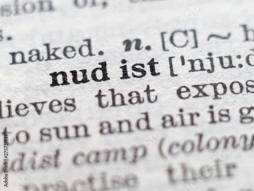 Dictionary definition of word nudist, selective focus.