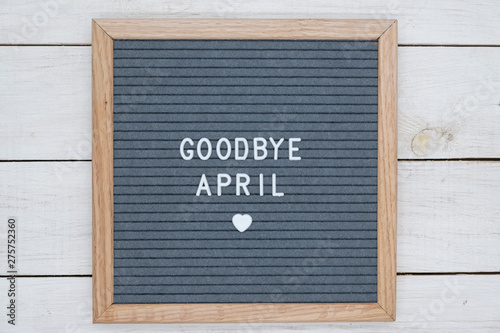 text in English goodbye April and a heart sign on a gray felt Board in a wooden frame