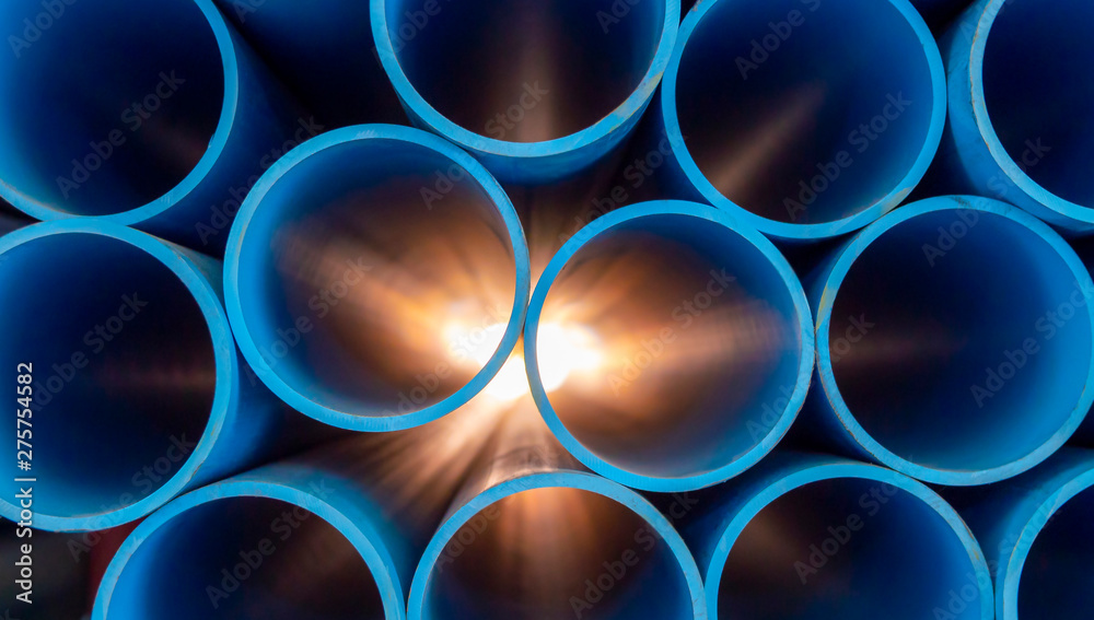 Group of blue water pipes That is stacked into a graphic format With light coming from behind - obrazy, fototapety, plakaty 