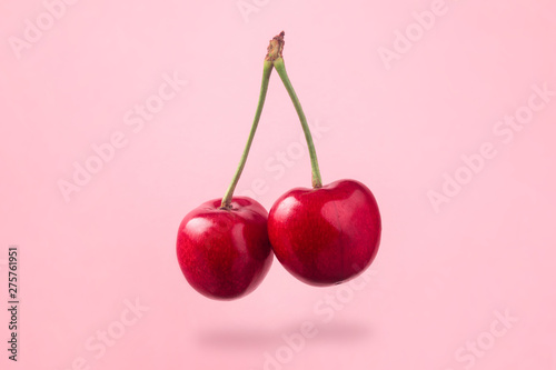 levitating red cherry over pink background
