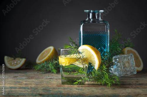 Cocktail with blue gin , tonic and lemon on a old wooden table .