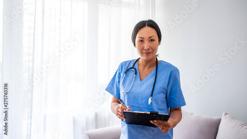  Woman healthcare worker with clipboard. Portrait of confident young Asian female doctor. Doctor with stethoscope around his neck looking at the camera photo