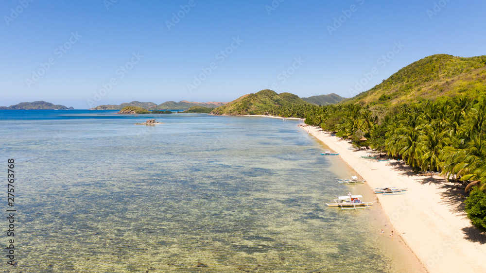 White sand beach near the rocks and boats.Palawan,Busuanga,Tropical beach for tourists aerial view