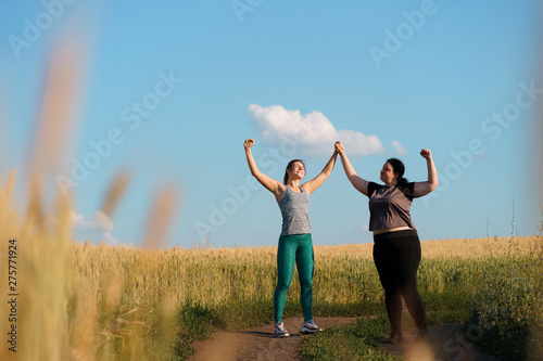 Friendship, motivation, group workout, weight loss. Two happy women friends give a five after jogging. Sports and health care