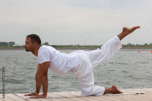 Young man doing yoga in morning park.man relax in nature