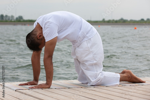 Young man doing yoga in morning park.man relax in nature