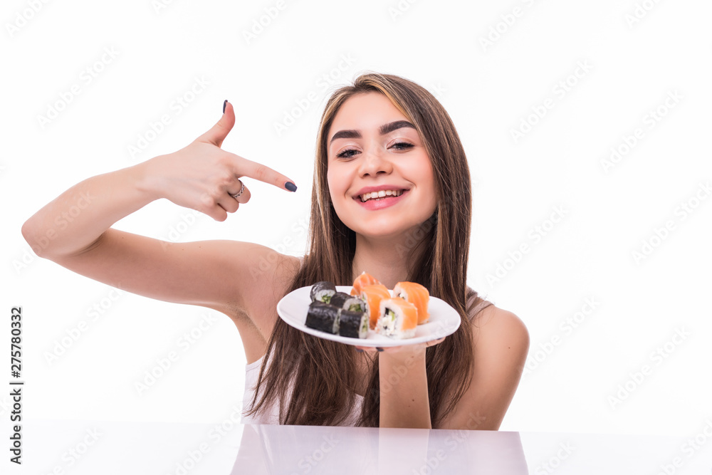 Young woman pointed on sushi piece with chopsticks against a white background Young woman pointed on sushi piece with chopsticks against a white background