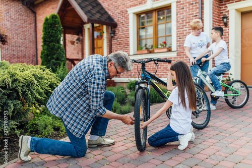 Wallpaper Mural Bike repair.Older  man repairing bike for his children. Home time, resting concept. Torontodigital.ca