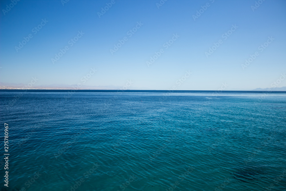 peaceful idyllic Red sea empty calm smooth water surface horizon board with blue sky nature scenery landscape simple background wallpaper pattern picture with copy space for text 
