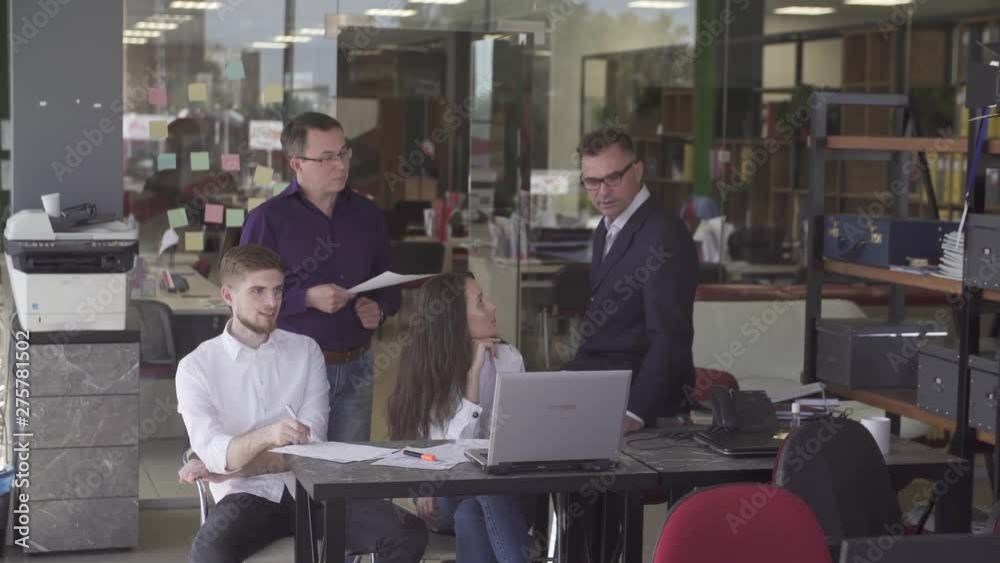 group of young businesspeople standing together in a modern office