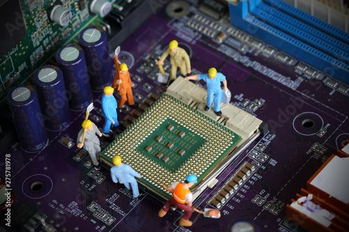 Photography Selective focus of miniature engineer worker to fixed mainboard and repair Control Processing Unit (CPU) processor, mainboard computer and use for computer industry background or business background