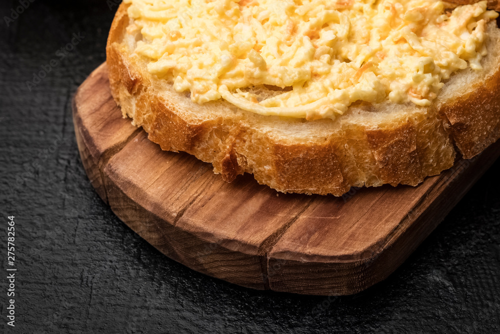 grated cheese sandwich with garlic on a slice of French baguette. Cooking snacks. Close up grated cheese sandwich with garlic on a slice of French baguette. Cooking snacks. Close up